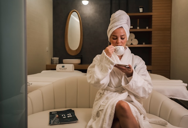 Lady drinking mint tea with robe in a spa